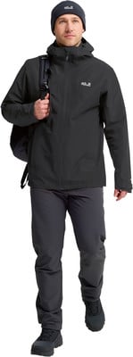 Ein Mann in schwarzer Kleidung und mit Rucksack geht nach vorne. Ein Mann in schwarzer Kleidung und mit Rucksack geht nach vorne.