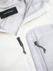 Detail einer Jacke mit Peak Performance Logo, Reißverschlüssen und Kordel.