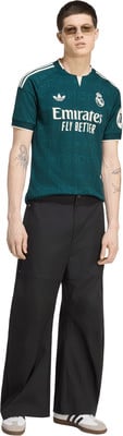 Ein Mann in einem grünen Fußballtrikot und einer schwarzen Hose. Ein Mann in einem grünen Fußballtrikot und einer schwarzen Hose.