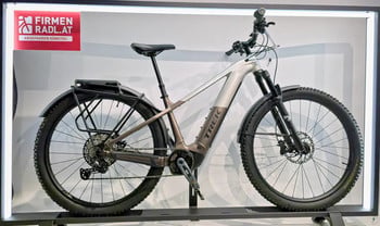Ein Trek E-Mountainbike mit Gepäckträger und Schutzblechen im Geschäft.