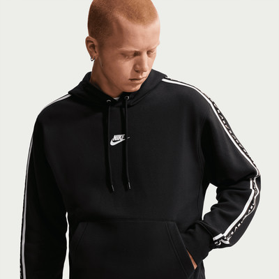 Ein Mann in einem schwarzen Nike Hoodie mit weißen Streifen an den Ärmeln. Ein Mann in einem schwarzen Nike Hoodie mit weißen Streifen an den Ärmeln.
