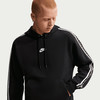 Ein Mann in einem schwarzen Nike Hoodie mit weißen Streifen an den Ärmeln.
