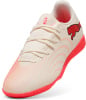 Beige Puma Fußballschuhe mit rotem Logo und Sohle.