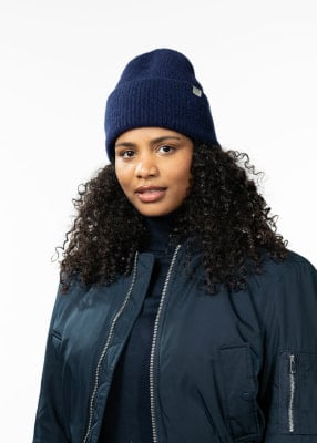 Frau mit lockigem Haar in dunkelblauem Hut und Jacke. Frau mit lockigem Haar in dunkelblauem Hut und Jacke.