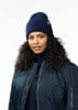 Frau mit lockigem Haar in dunkelblauem Hut und Jacke.