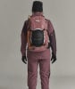 Eine Frau in Skibekleidung mit Rucksack und Eispickel auf dem Rücken.
