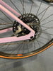 Hinterrad eines rosa Fahrrads mit Kassette und Schaltwerk.
