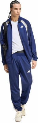 Mann in blauer Adidas Trainingshose und Jacke mit weißem T-Shirt. Mann in blauer Adidas Trainingshose und Jacke mit weißem T-Shirt.