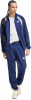 Mann in blauer Adidas Trainingshose und Jacke mit weißem T-Shirt.