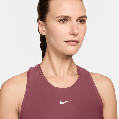 Frau in einem rosa Tanktop mit Nike-Logo trägt einen Zopf. Frau in einem rosa Tanktop mit Nike-Logo trägt einen Zopf.