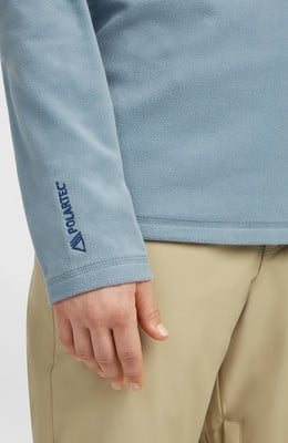 Blaue Fleecejacke mit Polartec-Logo am Ärmel. Blaue Fleecejacke mit Polartec-Logo am Ärmel.