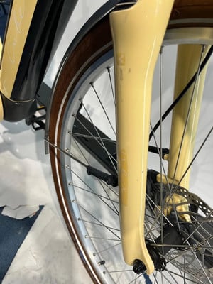 Detail der Vordergabel und des Fahrradrads in Beige. Detail der Vordergabel und des Fahrradrads in Beige.
