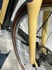 Detail der Vordergabel und des Fahrradrads in Beige.