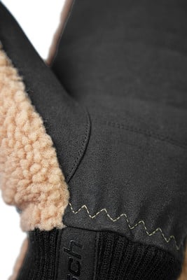 Detail eines schwarzen Lederhandschuhs mit beigem Fell und Nähten. Detail eines schwarzen Lederhandschuhs mit beigem Fell und Nähten.