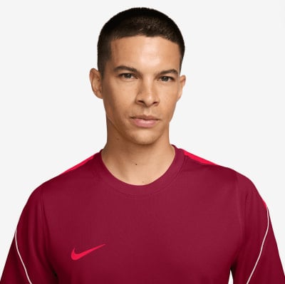 Egy férfi sötétvörös pólóban Nike logóval.