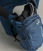 Ein Mann packt eine Skibrille und Handschuhe in einen Rucksack.