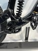 Detail der Rückseite eines schwarzen Mountainbikes mit Dämpfer und Kurbelgarnitur.