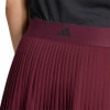 Detail eines plissierten roten Rocks mit Adidas-Logo auf einem dunkelroten Bund.