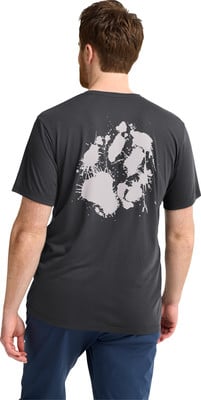 Ein Mann in einem dunklen T-Shirt mit einem Hundepfotenabdruck auf dem Rücken.