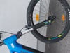 Ein blaues E-Mountainbike mit schwarzer Federung und großem Rad.