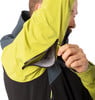 Ein Mann öffnet den Reißverschluss einer Jacke am Ärmel.
