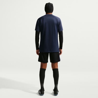 Ein Mann von hinten in einem dunkelblauen T-Shirt, schwarzer Hose und Socken. Ein Mann von hinten in einem dunkelblauen T-Shirt, schwarzer Hose und Socken.