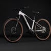 Silbernes Cube E-Bike mit braunen Reifen und schwarzem Hintergrund.