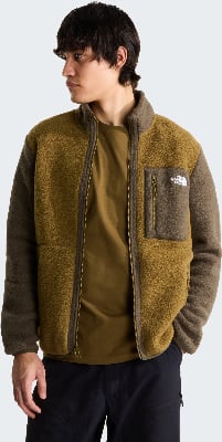 Ein Mann in einer braunen Fleecejacke mit Reißverschlusstasche und schwarzer Hose. Ein Mann in einer braunen Fleecejacke mit Reißverschlusstasche und schwarzer Hose.