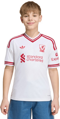 Junge in weißem Fußballtrikot mit roten Streifen und Logos Junge in weißem Fußballtrikot mit roten Streifen und Logos