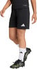 Kind in schwarzer Fußballshorts und Adidas-Schuhen mit weißen Socken.