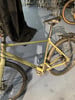 Ein grünes Cube-Fahrrad mit Gepäckträger und Schutzblechen steht auf einem blauen Teppich.