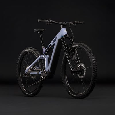 Ein vollgefedertes Elektrofahrrad in Grau mit schwarzen Details vor einem dunklen Hintergrund. Ein vollgefedertes Elektrofahrrad in Grau mit schwarzen Details vor einem dunklen Hintergrund.