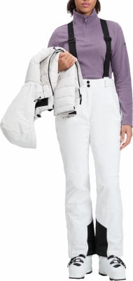 Eine Frau in Skikleidung hält eine weiße Jacke. Eine Frau in Skikleidung hält eine weiße Jacke.