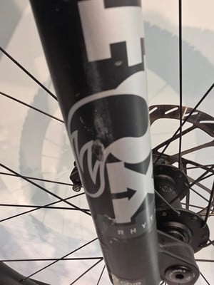 Detail eines Mountainbikes mit FOX-Logo und Bremsscheibe.