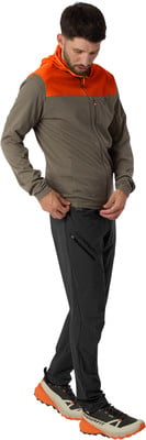 Mann in grauer Jacke mit oranger Kapuze und schwarzer Dynafit-Hose. Mann in grauer Jacke mit oranger Kapuze und schwarzer Dynafit-Hose.