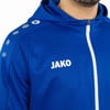 Blaue Kapuzenjacke mit Reißverschluss und JAKO-Logo auf der Brust.