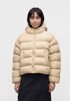 Dámská béžová péřová bunda Nike s kapucí a logem na hrudi.