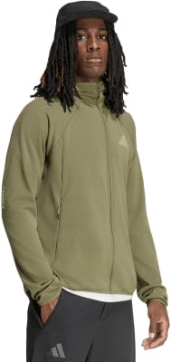 Ein Mann in einer grünen Jacke und schwarzer Kappe mit Dreadlocks.