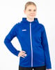 Eine Frau in einer blauen Kapuzenjacke mit weißem Reißverschluss steht vor weißem Hintergrund.