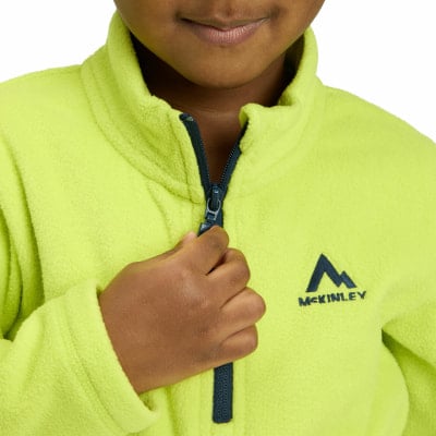 Ein Kind schließt eine neongrüne Fleecejacke mit McKinley-Logo. Ein Kind schließt eine neongrüne Fleecejacke mit McKinley-Logo.