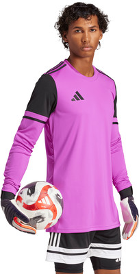 Ein Mann hält einen Fußball und trägt ein lila Langarmshirt.