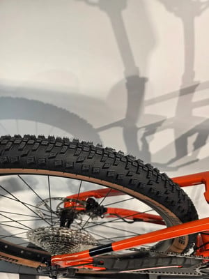 Das Hinterrad eines Mountainbikes mit orangefarbenem Rahmen und Dämpfung. Das Hinterrad eines Mountainbikes mit orangefarbenem Rahmen und Dämpfung.