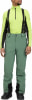 Ein Mann in grüner Skihose und gelbem Stehkragenpullover mit schwarzen Akzenten.