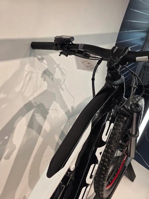 Ein schwarz-weißes Mountainbike mit Display am Lenker und Federung. Ein schwarz-weißes Mountainbike mit Display am Lenker und Federung.