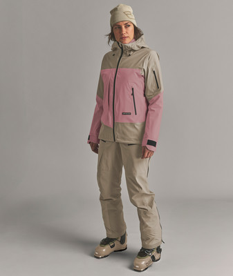 Eine Frau in einer Skijacke und Hose, trägt eine Mütze und Skischuhe. Eine Frau in einer Skijacke und Hose, trägt eine Mütze und Skischuhe.