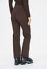 Eine Frau in brauner Skihose und HEAD-Skischuhen.