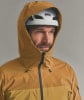 Ein Mann in einer gelben Kapuzenjacke und einem weißen Petzl-Helm.