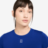 Eine Frau in einem blauen T-Shirt mit Nike-Logo auf der Brust.