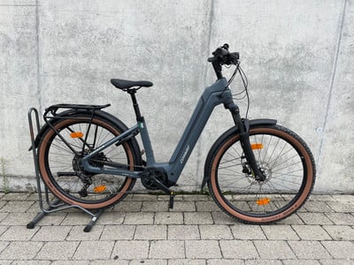 Graues Conway E-Bike auf einem Ständer vor einer Betonwand. Graues Conway E-Bike auf einem Ständer vor einer Betonwand.