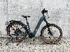 Graues Conway E-Bike auf einem Ständer vor einer Betonwand.